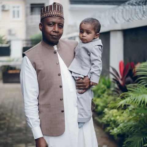 A father holding his young son in traditional clothing