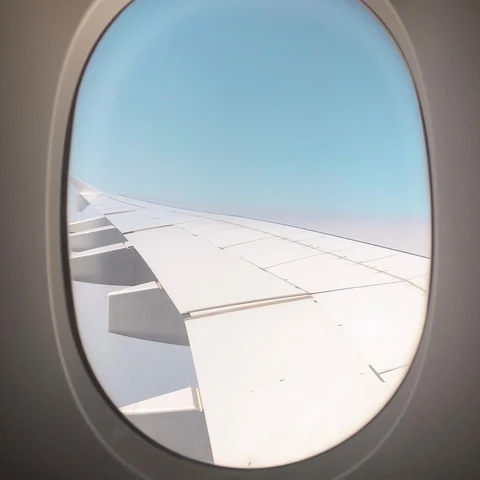 An airplane wing seen through a passenger window
