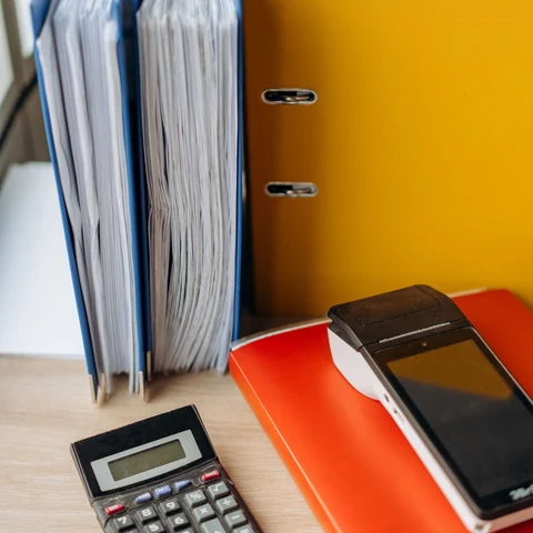 A calculator and financial records arranged on a desk